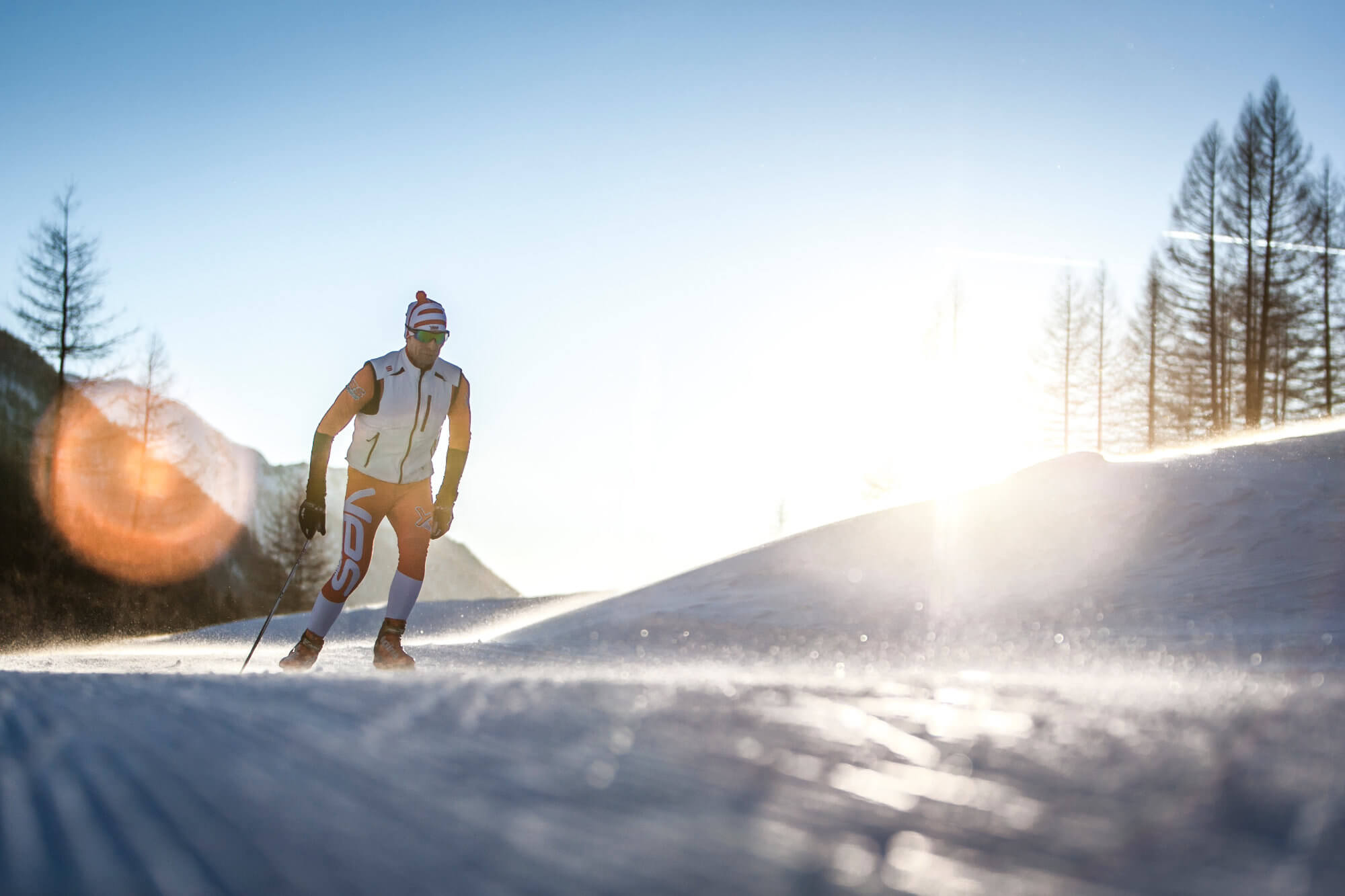 Langläufer an einem sonnigen Wintertag auf der Loipe - AHRIA Apartments