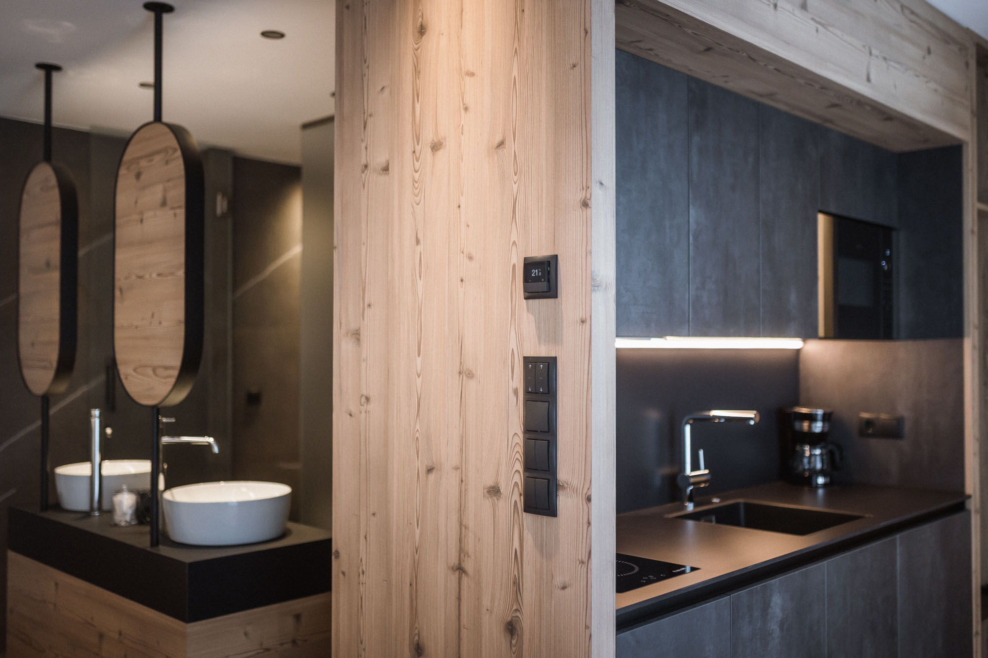 Blick auf die Küchenzeile und das Badezimmer im Hintergrund vom Apartment AhriaNova - AHRIA Apartments