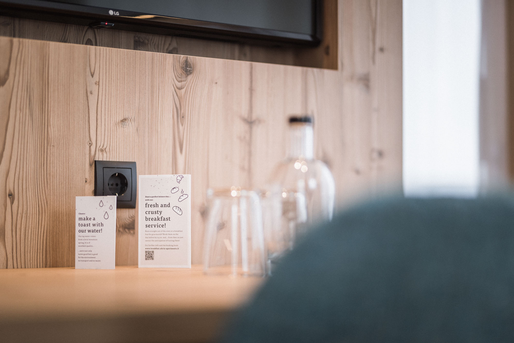Wasserflasche mit Infokärtchen auf dem Tisch im Apartment AhriaNova - AHRIA Apartments