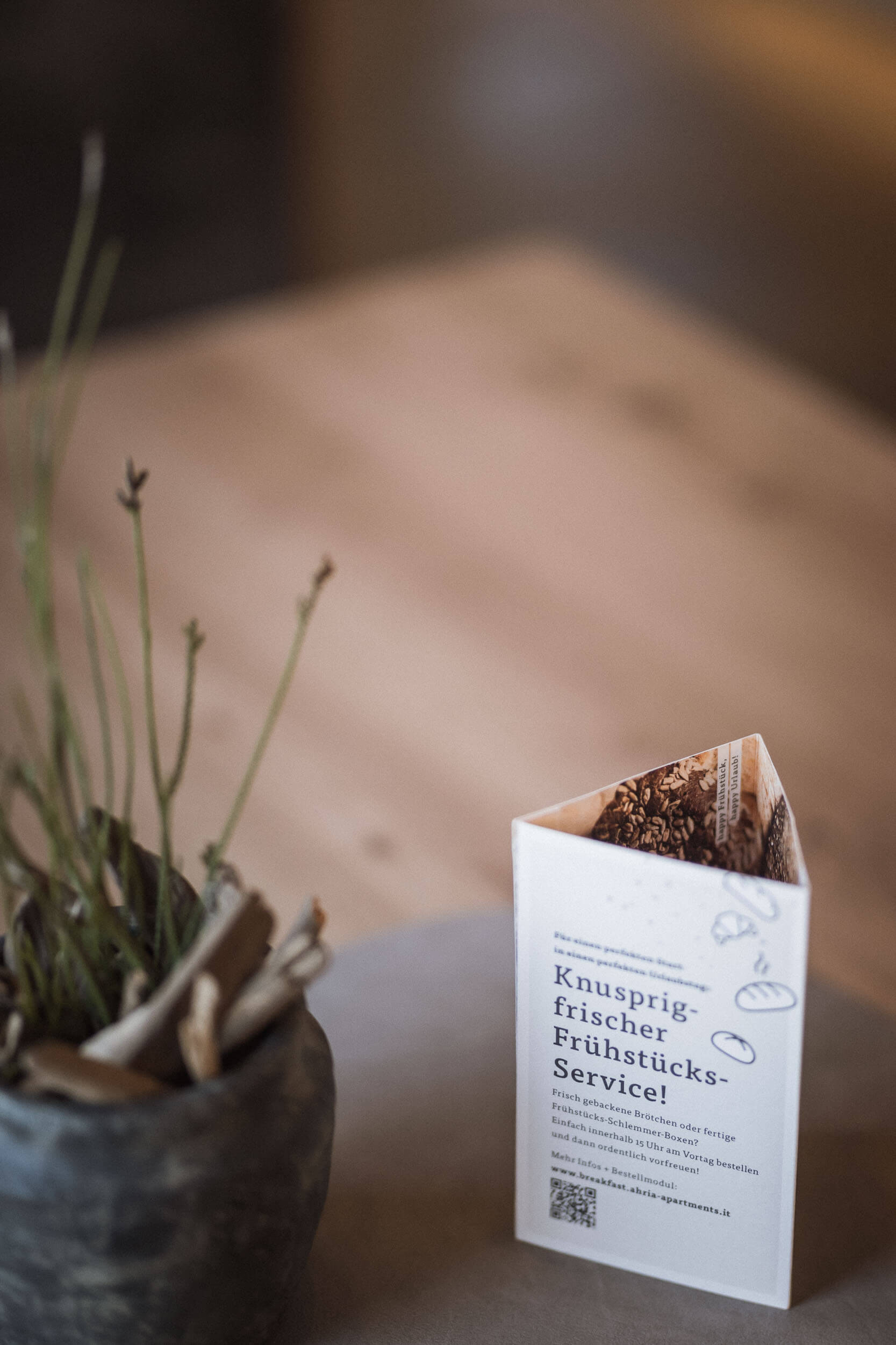 Infokärtchen auf dem Tisch für den Frühstücksservice im Apartment AhriaNova - AHRIA Apartments