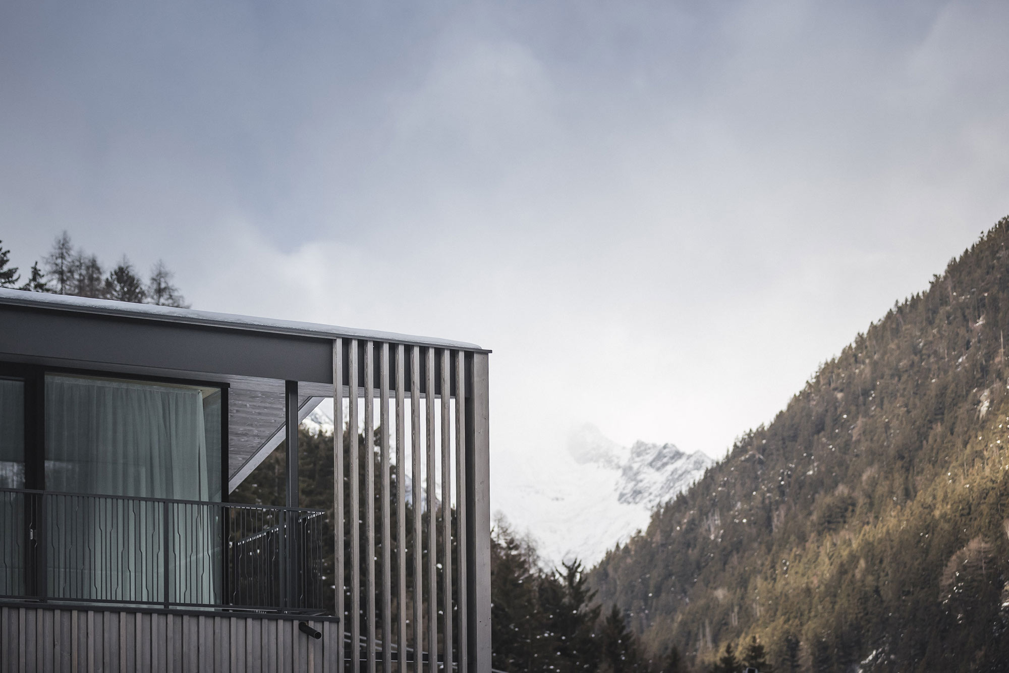 Vom Balkon des Apartments AhriaNova blickt man auf eine verschneite Berglandschaft - AHRIA Apartments