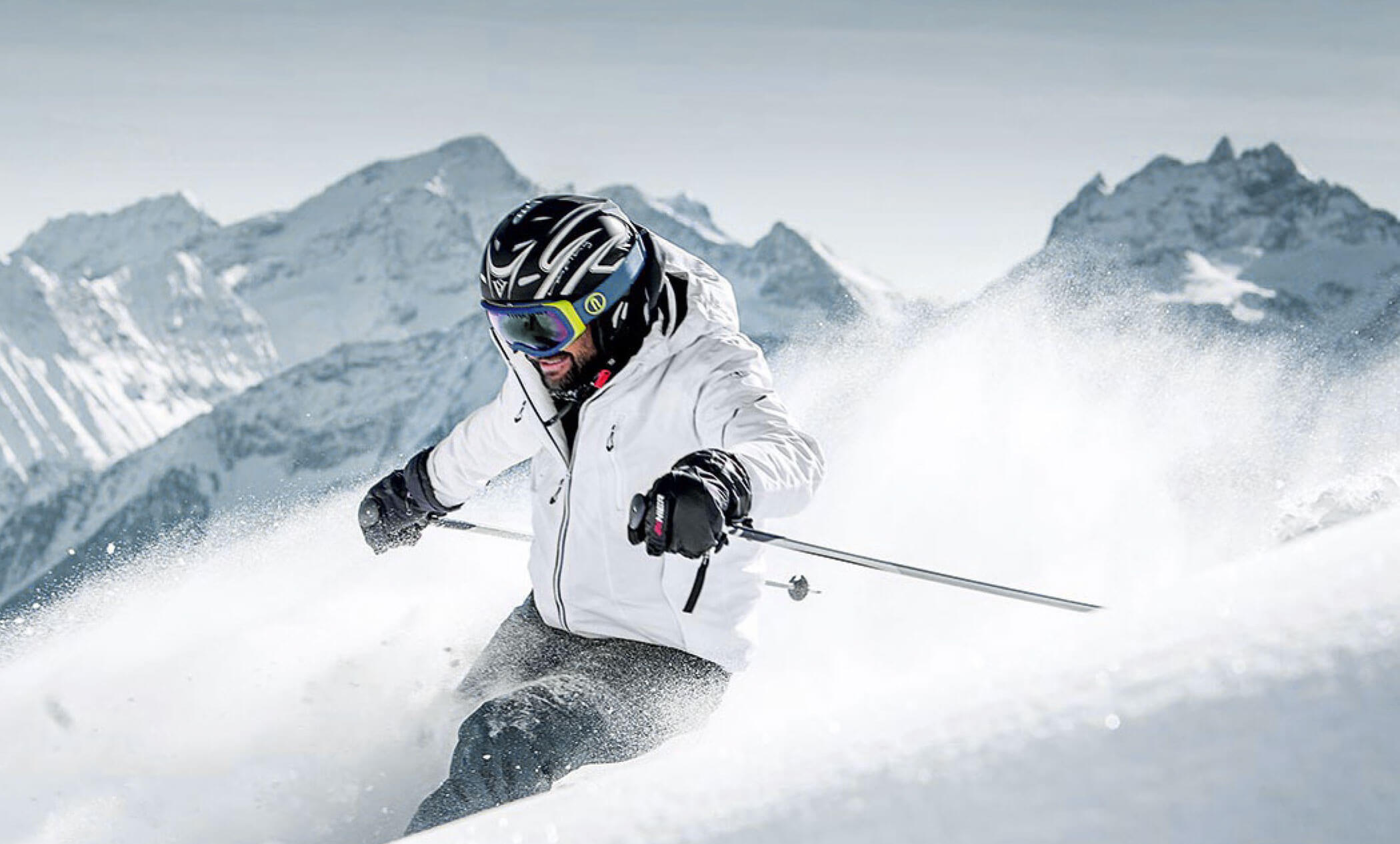 Skifahrer mit weißer Skijacke beim Skifahren im Ahrntal - AHRIA Apartments