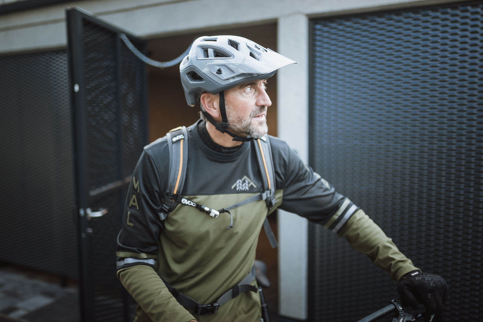 Mann mit Helm und Fahrrad auf dem Weg zum Biken im Ahrntal - AHRIA Apartments