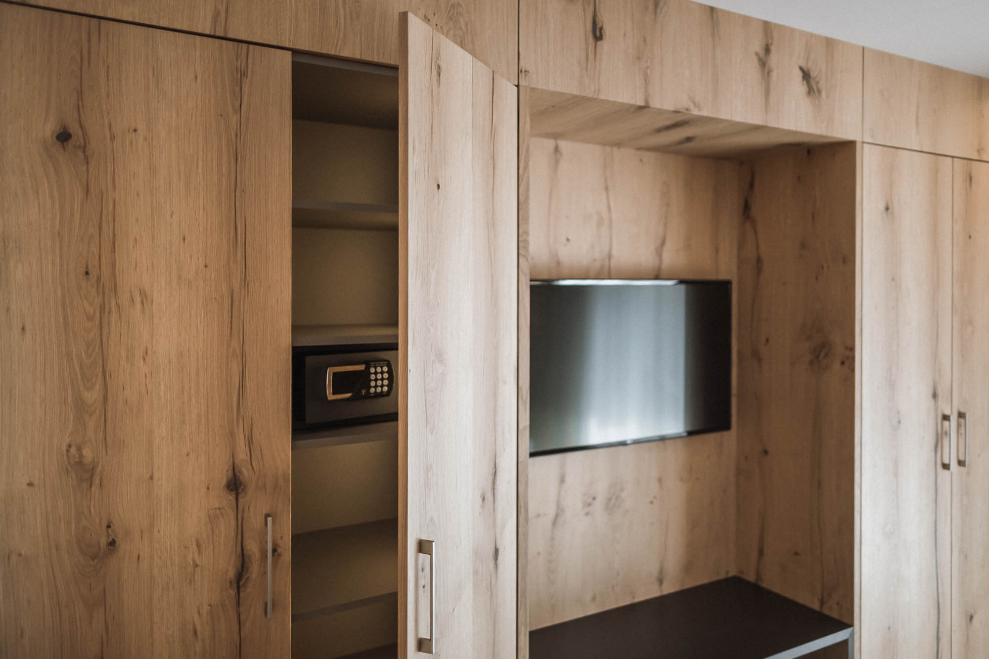 Kleiderschrank mit Fernseher und eingebautem Hotelsafe im AhriaPura Apartment - AHRIA Apartments