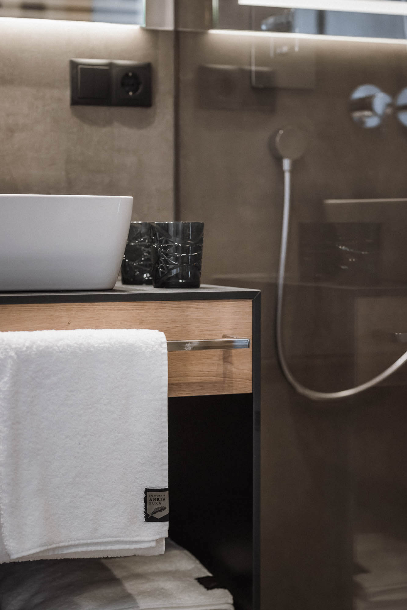 Unterschrank vom Waschbecken mit Handtücher im AhriaPura Apartment - AHRIA Apartments