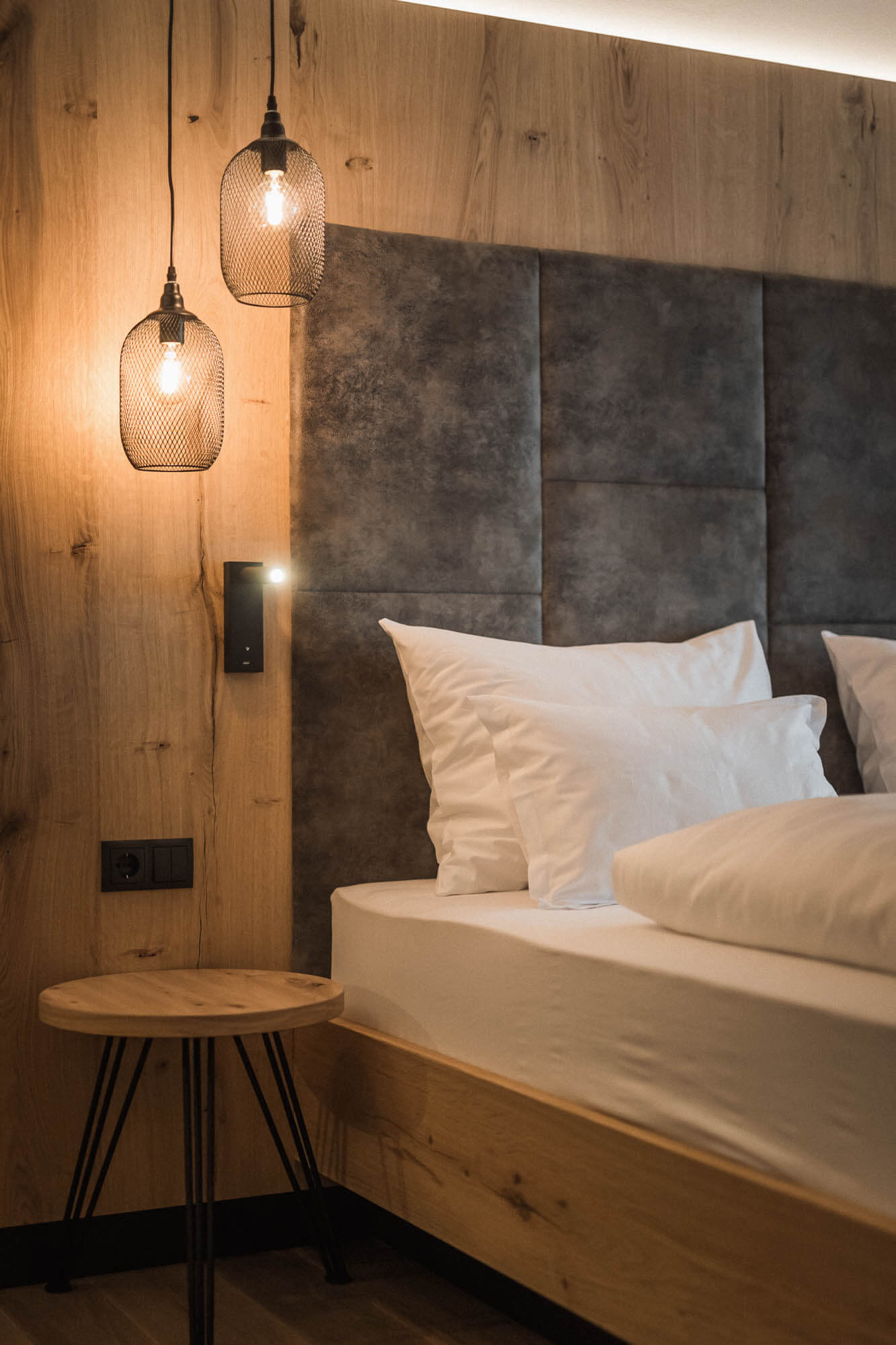 Doppelbett mit Nachttischchen und Hängelampen im AhriaPura Apartment - AHRIA Apartments