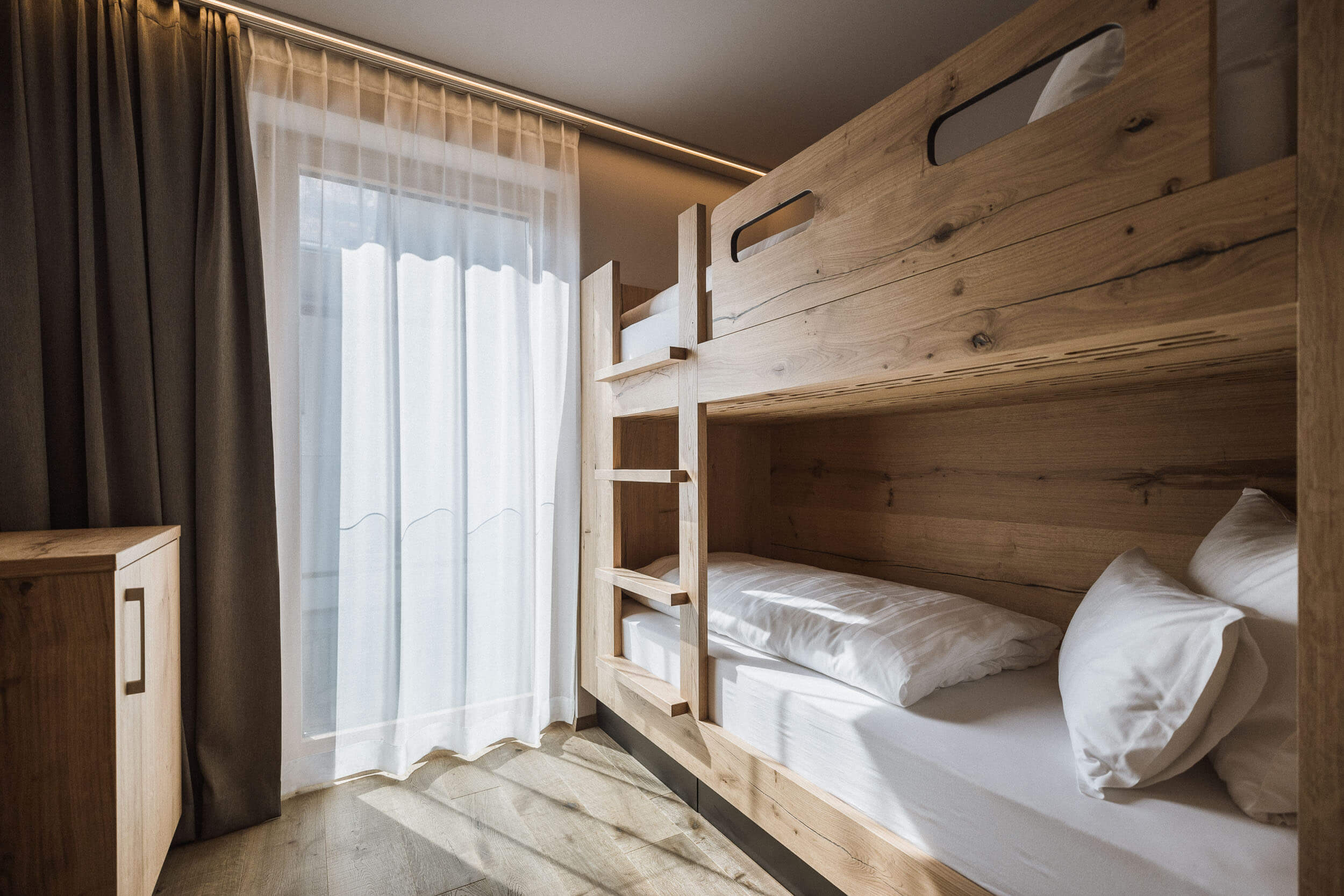 Kinderzimmer mit Holzmöblierung vom AhriaPura Apartment - AHRIA Apartments