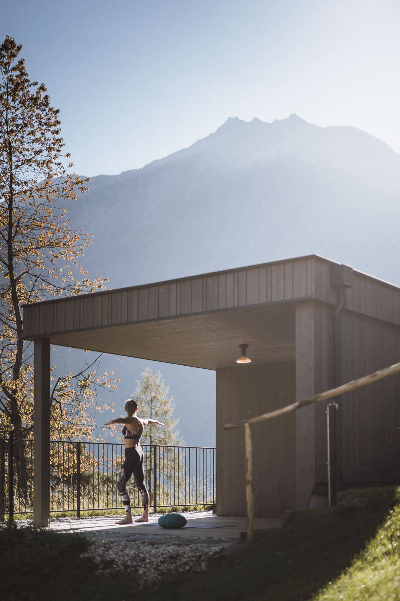 Frau macht Yoga auf der Terrasse vom AhriaPura Apartment - AHRIA Apartments