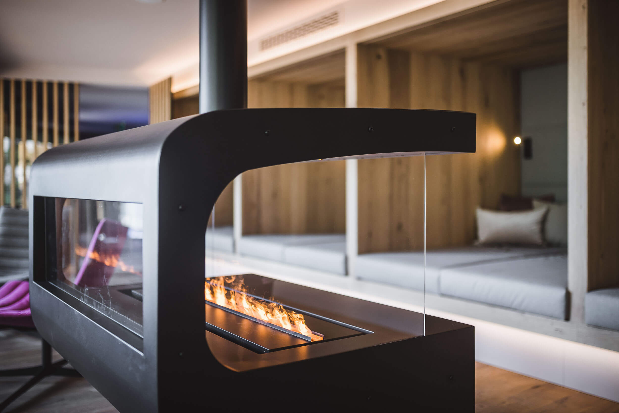 Ofen mit loderndem Feuer im Ruheraum im AhriaPura Apartment - AHRIA Apartments