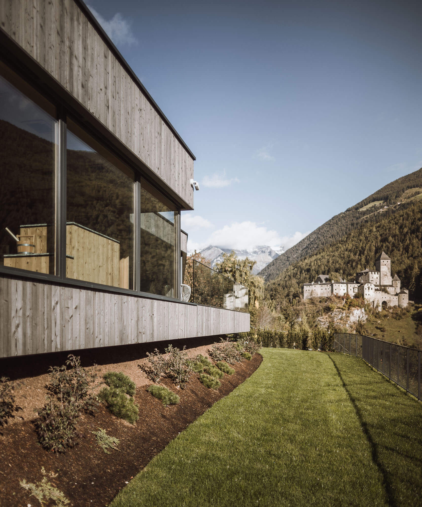 Grüner Rasen vor dem Apartment AhriaPura mit Blick auf Schloss Taufers und in die Sauna - AHRIA Apartments