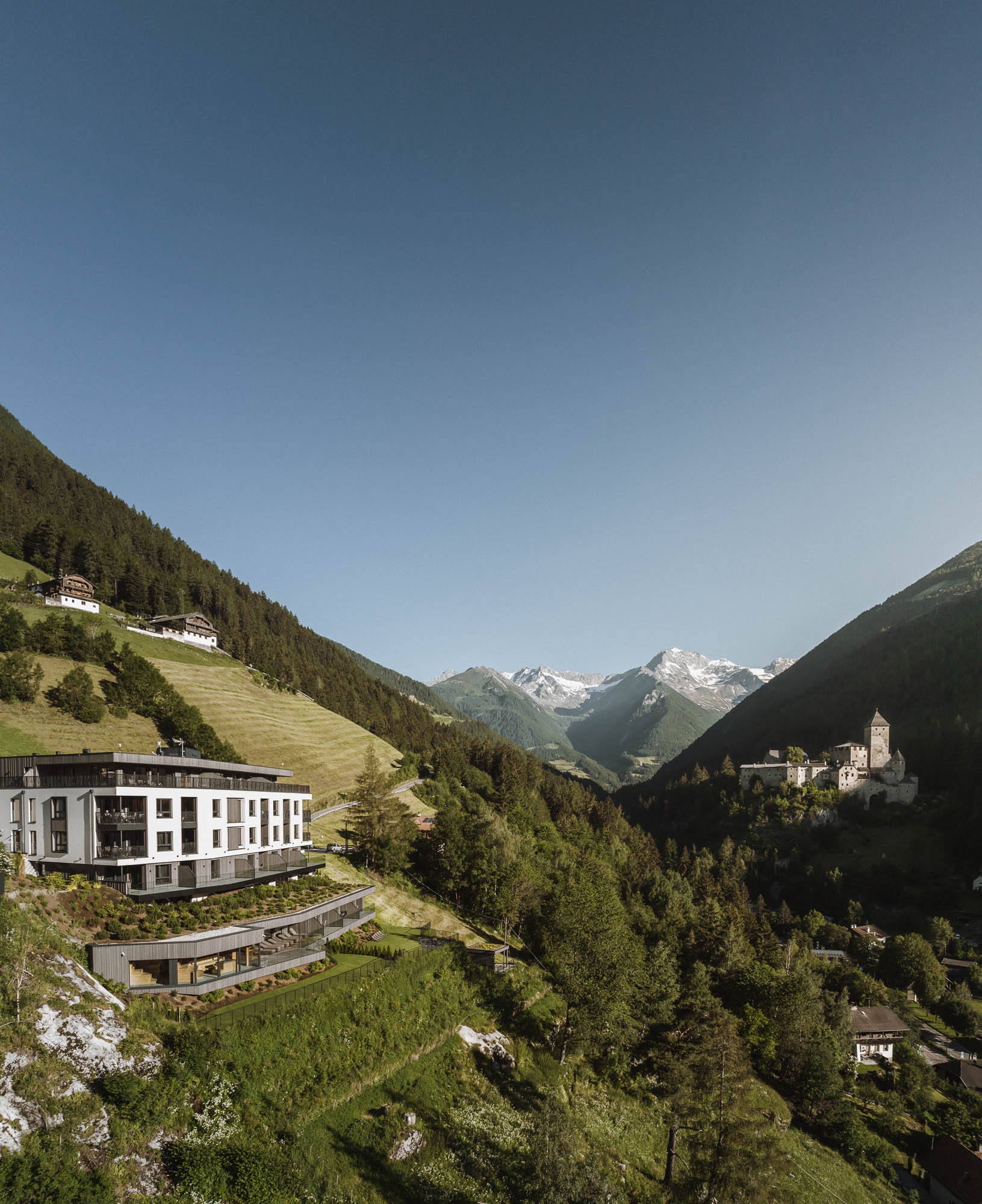 Drohnenaufnahme vom Apartment AhriaPura mit Schloss Taufers und das Ahrntal im Hintergrund - AHRIA Apartments