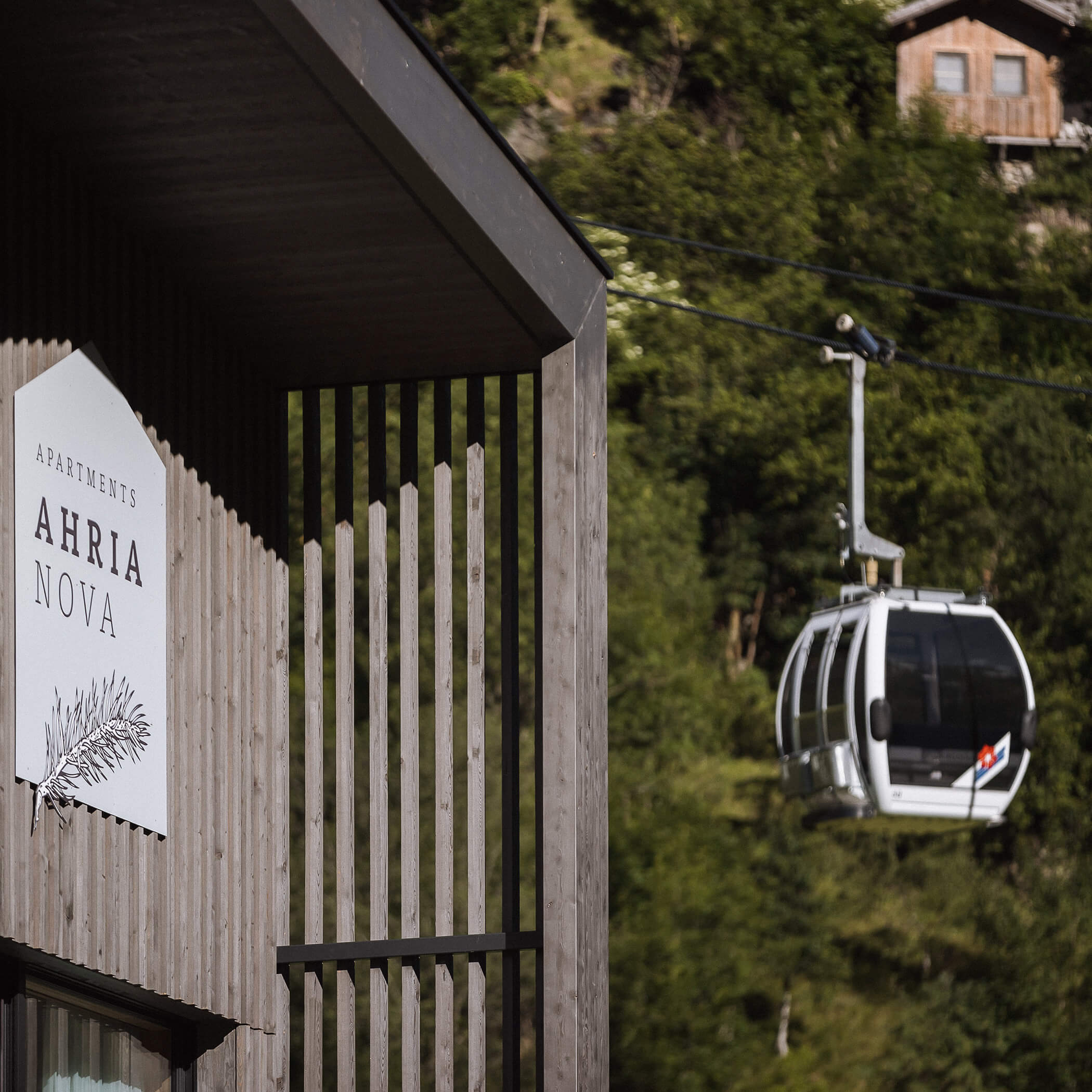 Gondel fährt im Sommer neben dem Ahria Pura Apartment vorbei - AHRIA Apartments